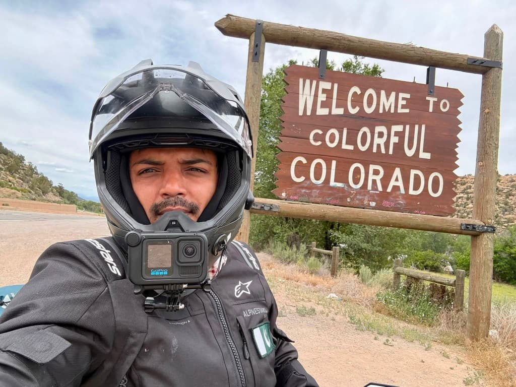 Colorado welcome sign with loaded adventure motorcycle