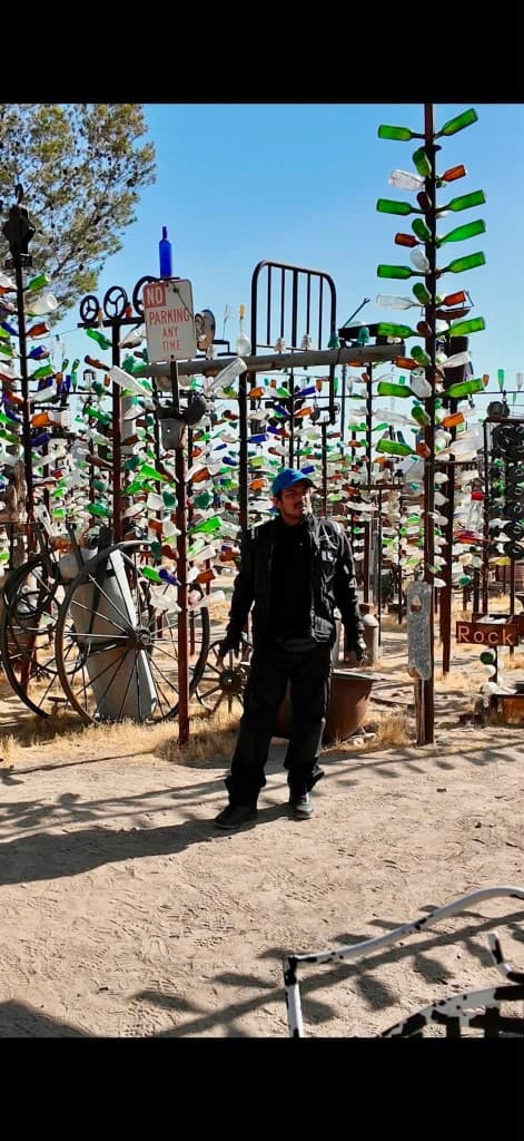 Rider standing among bottle trees at Bottle Tree Ranch on Route 66