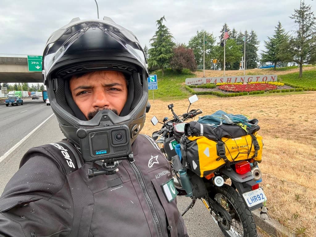 Selfie at the Washington welcome sign with Pakistani flag on jacket