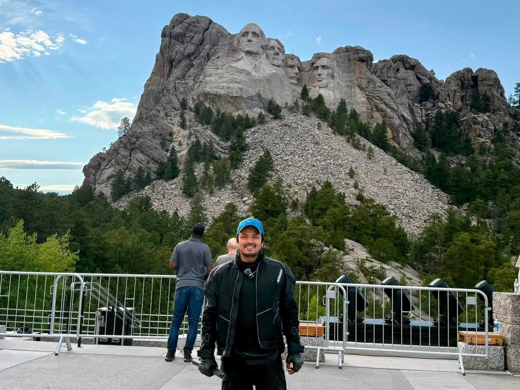 Rider smiling in front of Mount Rushmore National Memorial