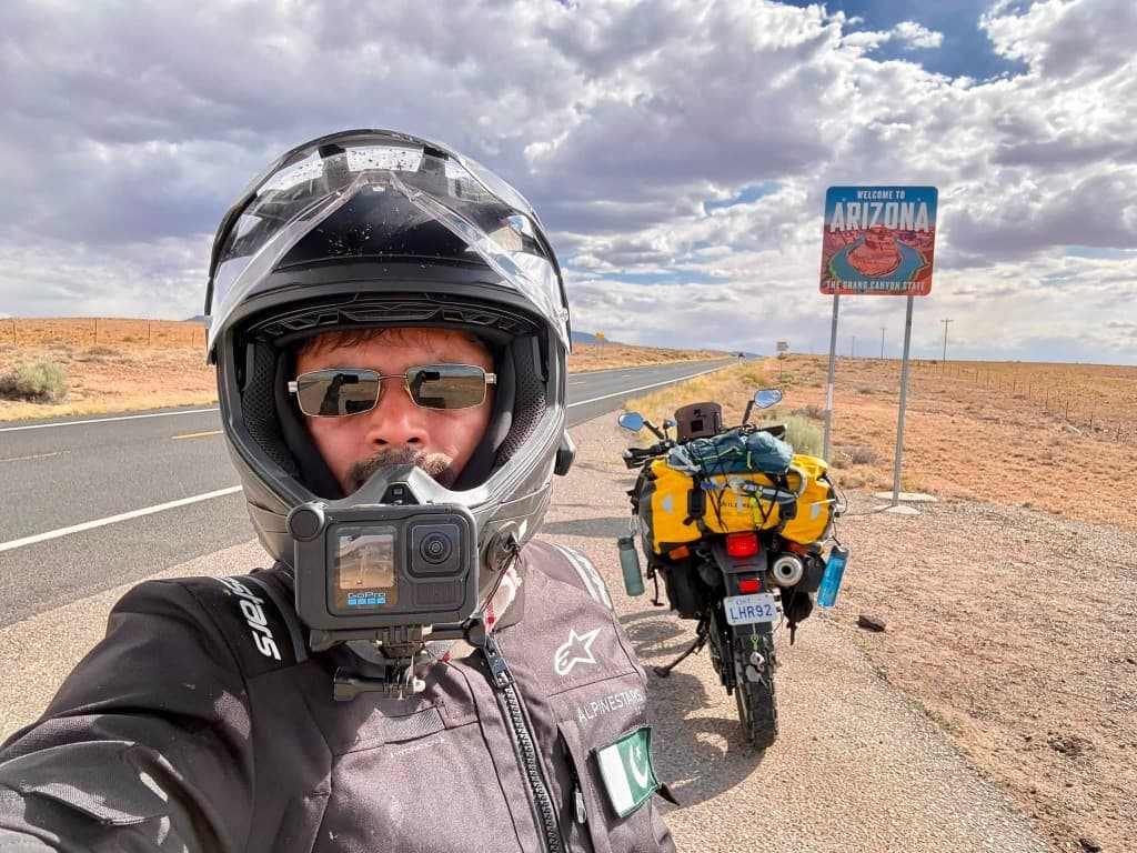 Arizona welcome sign with loaded adventure motorcycle