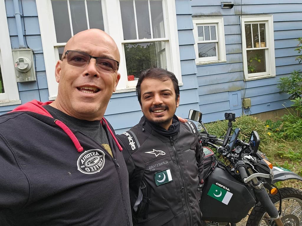 Selfie with Astoria Coffee Co. host beside loaded DR650 with Pakistani flag